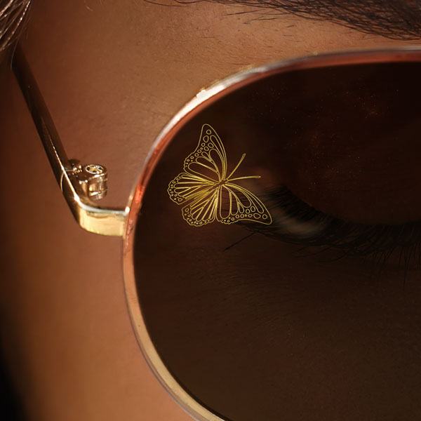 Close up of a woman wearing sun glasses with a SpecTats Butterflies design