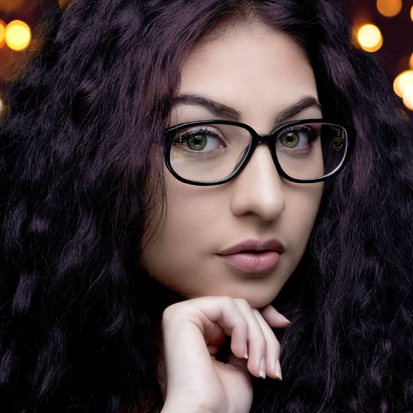 woman wearing clear glasses with a SpecTats Celestial design