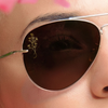 Close up of a woman wearing sun glasses with a SpecTats Floral Flourish design