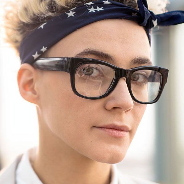 woman wearing clear glasses with a SpecTats Gender Symbol design
