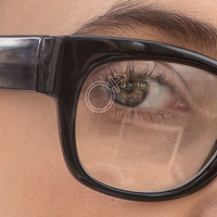 Close up of a woman wearing clear glasses with a SpecTats Gender Symbol design