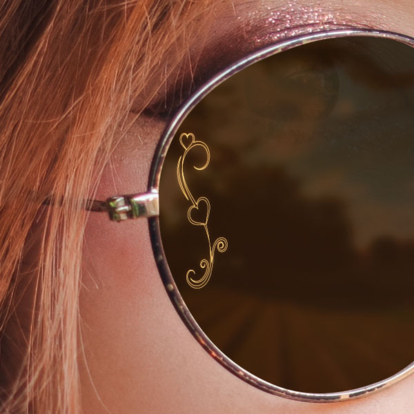 Close up of a woman wearing sun glasses with a SpecTats Heart Flourish design