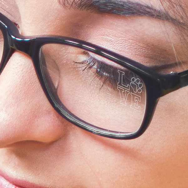 Close up of a woman wearing clear glasses with Paws n' Claws SpecTats design