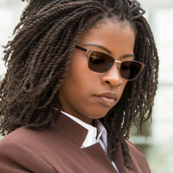 woman wearing brown polarized sunglasses with a SpecTats Vintage Letter design