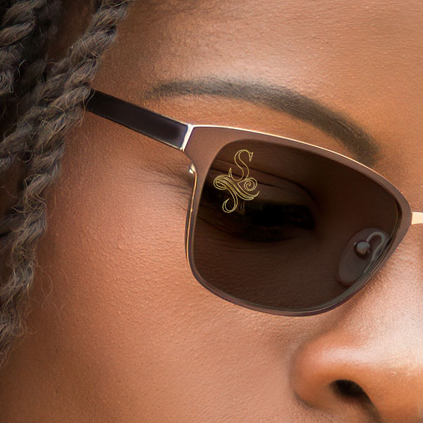 Close up of a woman wearing brown polarized sunglasses with a SpecTats Vintage Letter design