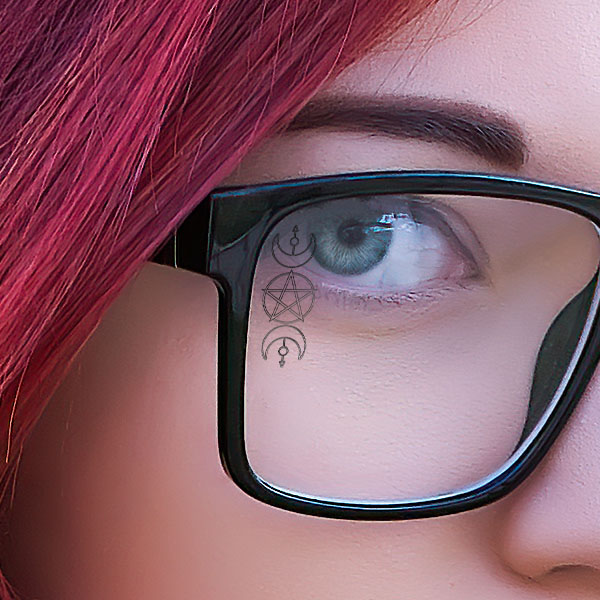 Close up of a woman wearing clear glasses with a Wiccan SpecTats design